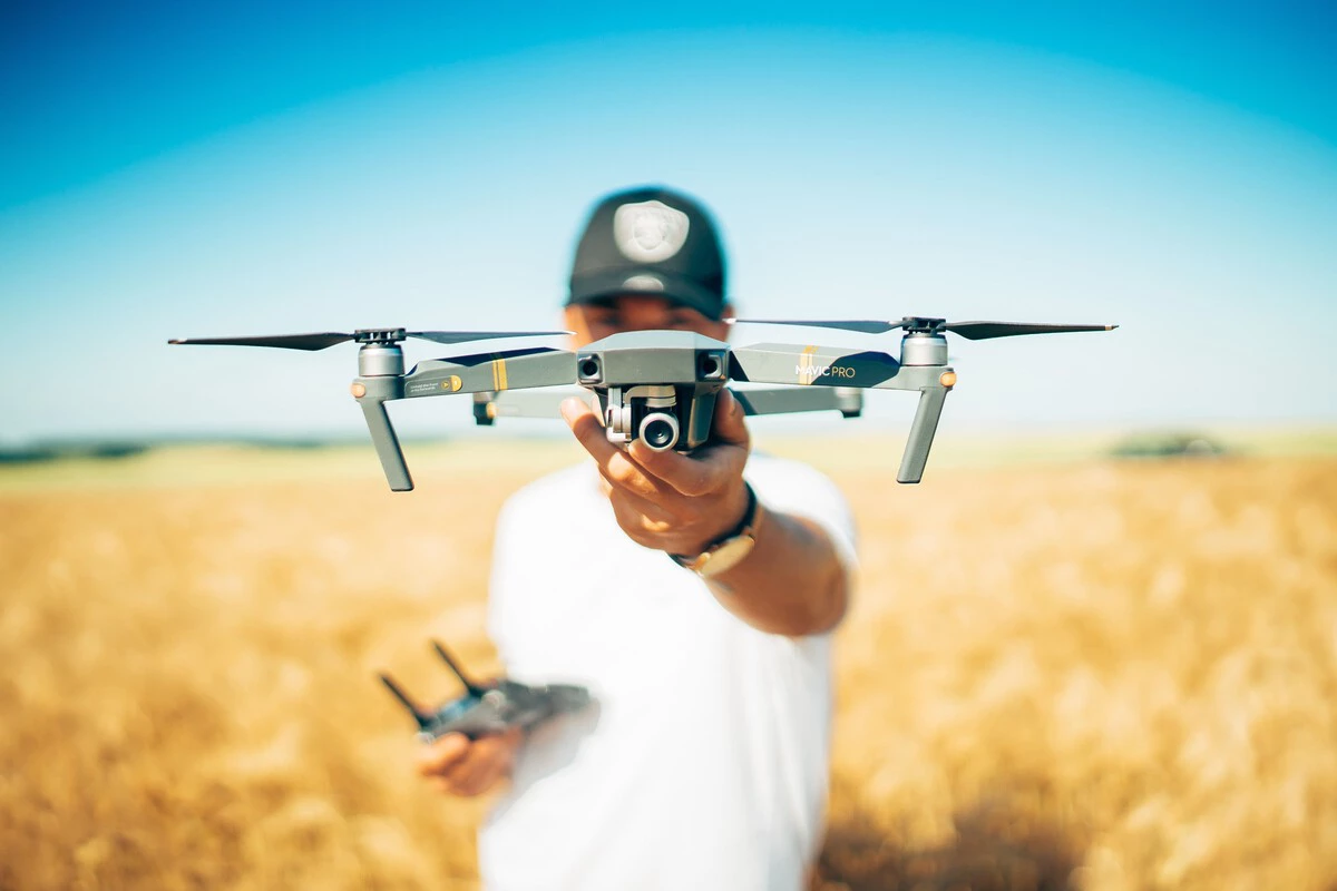 Commercial drone pilot holding a Mavic Pro drone, controller in hand